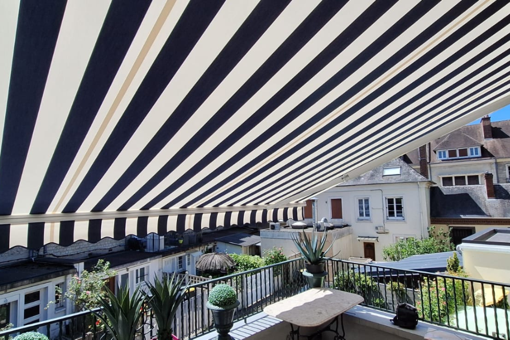 Store banne Jade déployé vue balcon aux Andelys (27) – motorisation radio Somfy