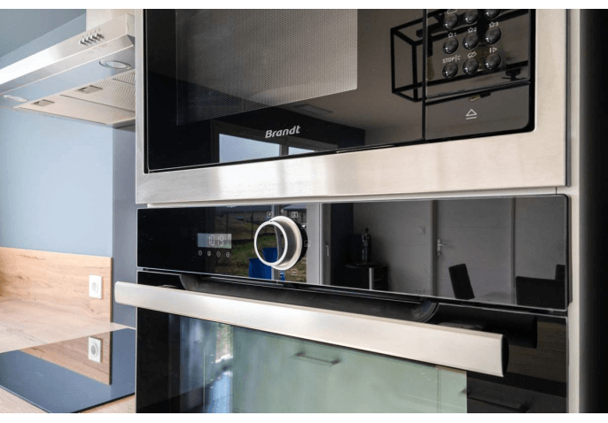 Cuisine sur-mesure équipée au style contemporain avec îlot central et électroménager encastrable