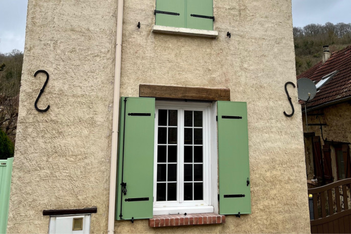 Détail d’un volet battant aluminium sur mesure vert pâle avec ferrures noires à Vernon