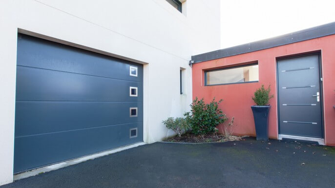 Porte de garage sectionnelle coordonnée avec la porte d'entrée aluminium à La Baule